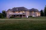 This stunning stone-clad home offers a luxurious lifestyle with a spacious elevated deck perfect for entertaining and enjoying the twilight views.