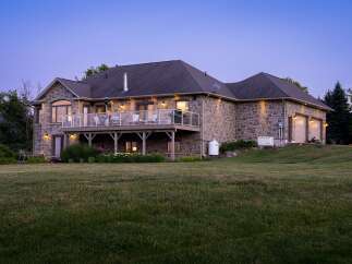 This stunning stone-clad home offers a luxurious lifestyle with a spacious elevated deck perfect for entertaining and enjoying the twilight views.