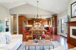 Experience the epitome of open-concept living in this stunning home, featuring a spacious kitchen with rich wood cabinetry and a large island, seamlessly flowing into a bright dining area perfect for gatherings.