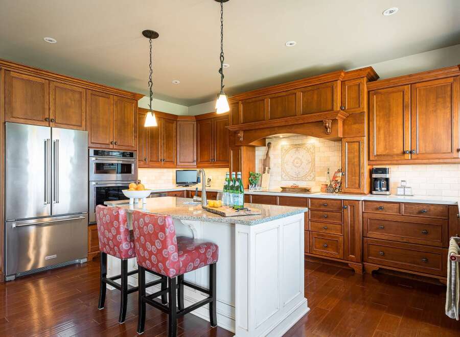 Experience luxury in this stunning kitchen featuring rich cherry wood cabinetry and a spacious island perfect for entertaining.