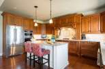 Experience luxury in this stunning kitchen featuring rich cherry wood cabinetry and a spacious island perfect for entertaining.