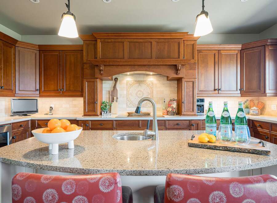 Experience luxury in this stunning kitchen featuring rich cherry wood cabinetry and a spacious granite island perfect for entertaining.