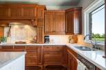 Experience luxury in this stunning kitchen featuring custom cherry wood cabinetry and elegant granite countertops.
