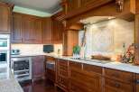 Experience luxury in this stunning kitchen featuring rich, dark wood cabinetry and a sleek, modern induction cooktop.