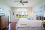 Experience luxury living in this stunning bedroom featuring a spacious king-sized bed adorned with plush pillows and a textured white duvet.