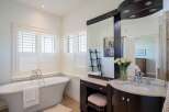 Indulge in luxury in this stunning bathroom featuring a freestanding soaking tub and a spacious vanity with a double sink.