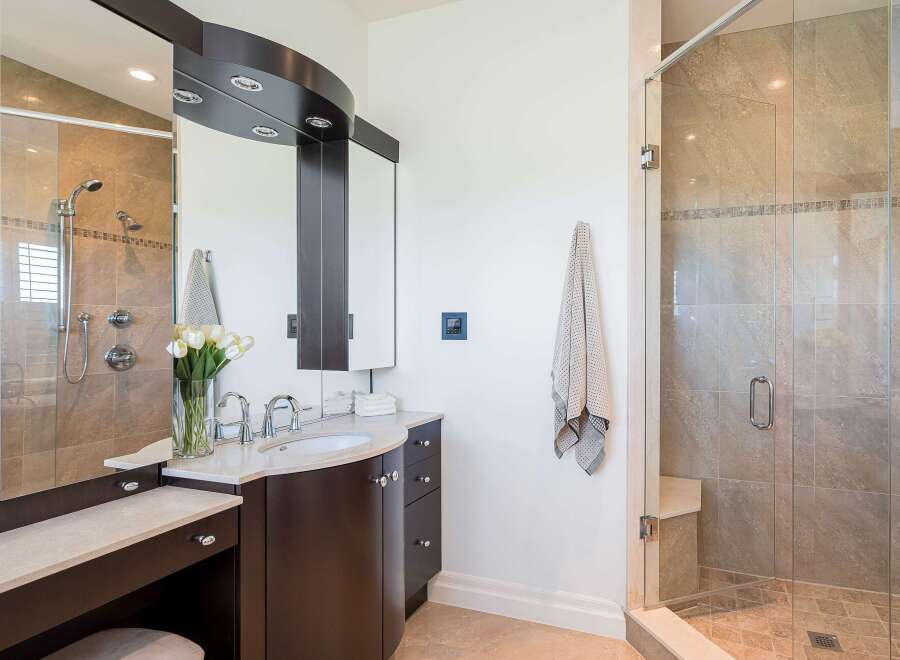 Experience luxury in this stunning bathroom featuring a spacious glass-enclosed shower with dual showerheads and a built-in bench.