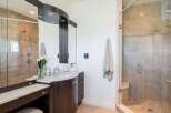 Experience luxury in this stunning bathroom featuring a spacious glass-enclosed shower with dual showerheads and a built-in bench.