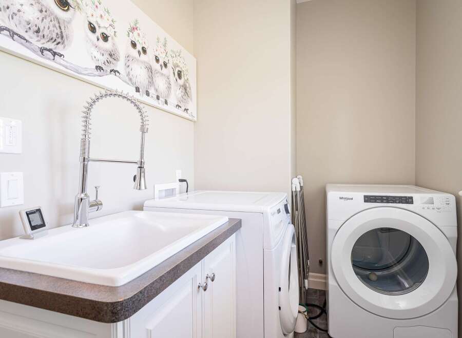 This laundry room features a spacious utility sink with a high-arc faucet, perfect for pre-treating clothes or hand-washing delicate items.