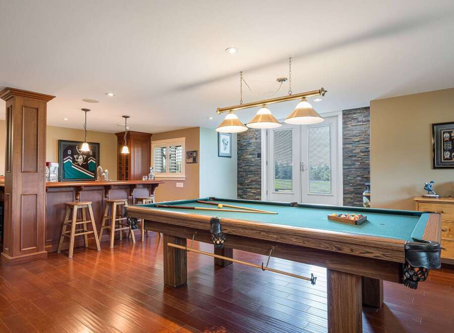 Step into this ultimate entertainment space, featuring a full-service bar with ample seating and a professional-grade pool table perfect for friendly games.