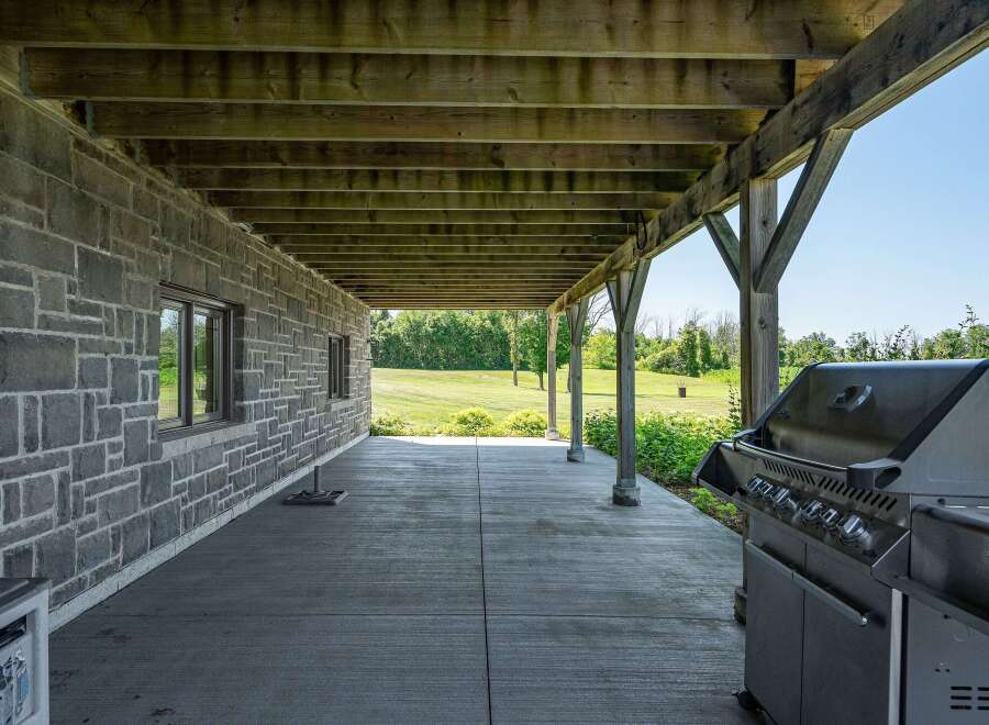 Enjoy outdoor living with this covered patio featuring a built-in grill, perfect for entertaining.