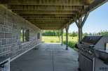 Enjoy outdoor living with this covered patio featuring a built-in grill, perfect for entertaining.
