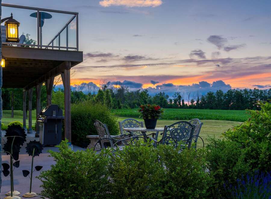 Enjoy breathtaking sunsets from this stunning backyard oasis, complete with a spacious deck and a charming patio set perfect for al fresco dining.