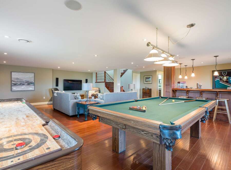 Experience ultimate entertainment in this finished basement featuring a full-size pool table and a shuffleboard court.