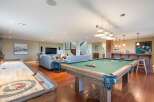 Experience ultimate entertainment in this finished basement featuring a full-size pool table and a shuffleboard court.