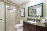 This modern bathroom features a spacious glass-enclosed shower with tiled walls and a sleek chrome showerhead.