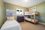 This charming bedroom features a cozy bunk bed and a twin bed, perfect for accommodating family or guests.