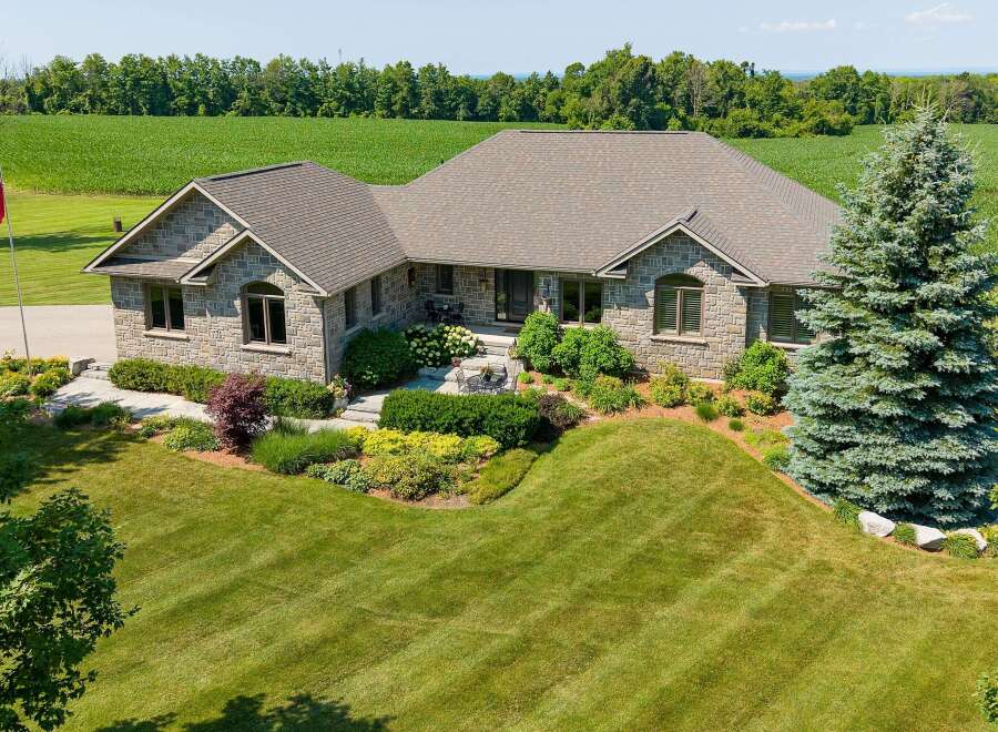 Discover this stunning stone-clad residence nestled amidst picturesque farmland and mature trees.