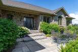 This charming home features a beautiful stone exterior and a welcoming entrance with a covered porch.