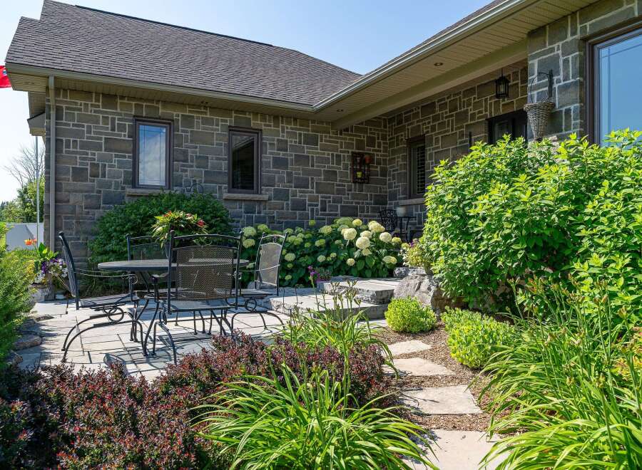 Enjoy outdoor living on this charming stone patio, perfect for al fresco dining or relaxing with a good book.