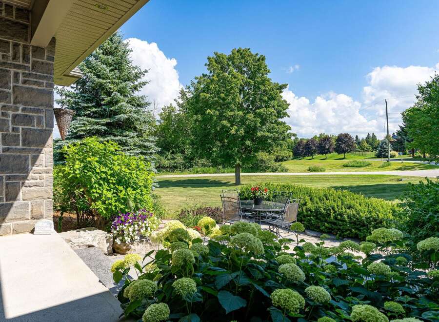 Enjoy outdoor living with this charming patio featuring a glass-top dining table and chairs, perfect for al fresco meals.