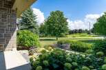 Enjoy outdoor living with this charming patio featuring a glass-top dining table and chairs, perfect for al fresco meals.