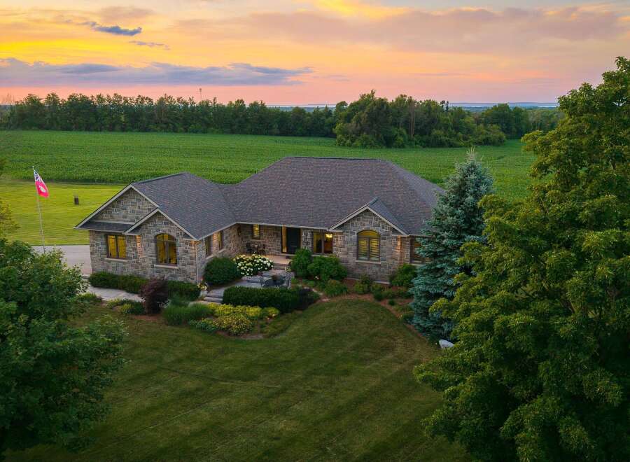 Experience luxurious country living in this stunning stone-clad home, nestled amidst picturesque farmland and mature trees.