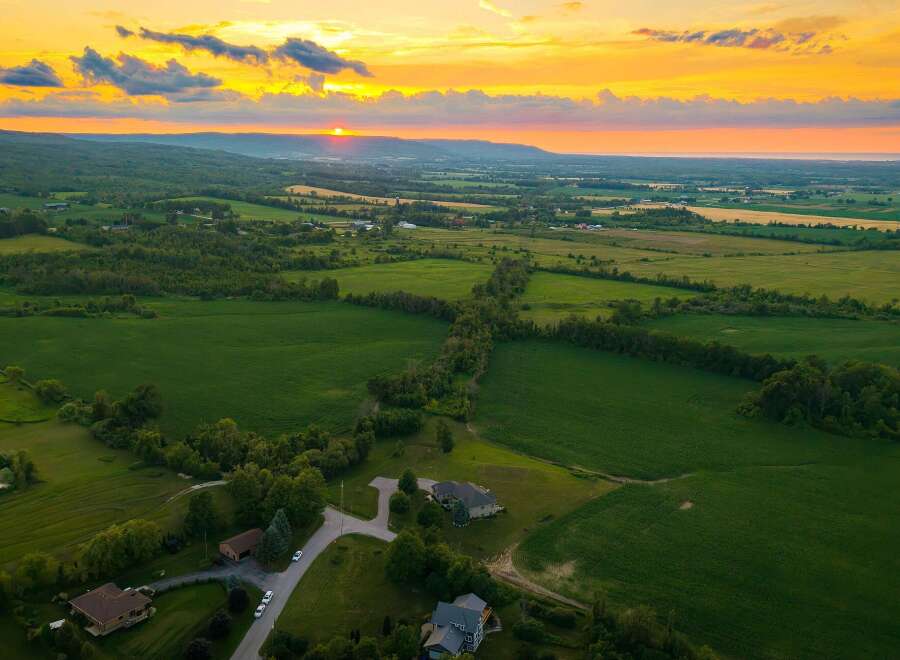 Experience breathtaking sunset views over rolling green fields from this stunning property.
