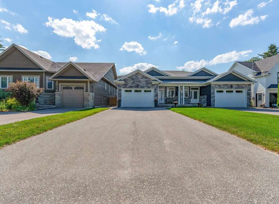 Discover modern living in this stunning property featuring a beautifully landscaped exterior and a spacious driveway leading to multiple garage doors.