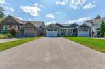 Discover modern living in this stunning property featuring a beautifully landscaped exterior and a spacious driveway leading to multiple garage doors.