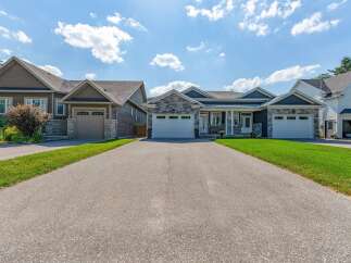 Discover modern living in this stunning property featuring a beautifully landscaped exterior and a spacious driveway leading to multiple garage doors.