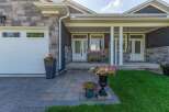 Welcome to this charming home featuring a welcoming covered porch with ample seating and beautiful floral arrangements.