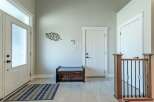 Step into this welcoming entryway featuring a frosted glass front door and a convenient storage bench.