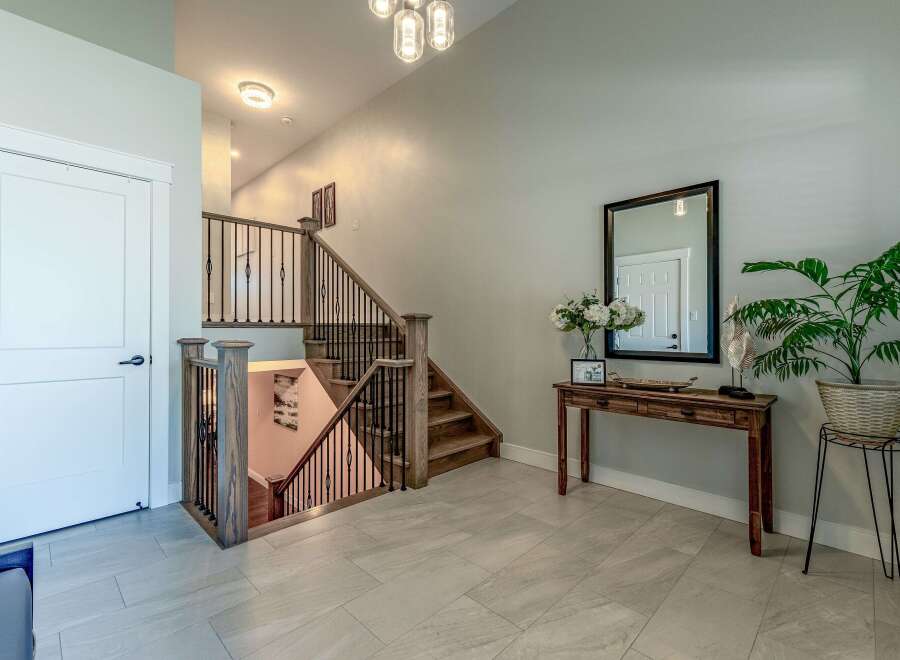 Step into this inviting entryway featuring a modern staircase with dark metal spindles and rich wood accents.