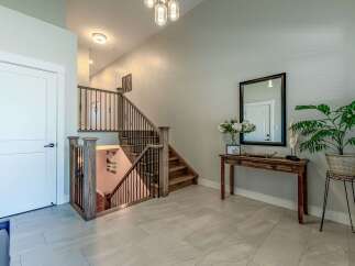 Step into this inviting entryway featuring a modern staircase with dark metal spindles and rich wood accents.