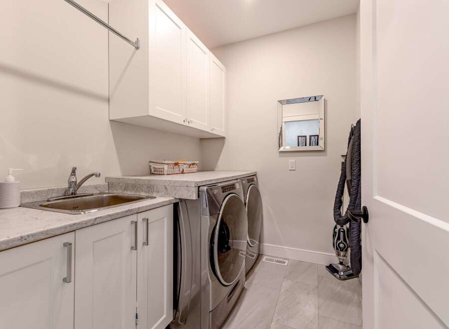 This laundry room features a convenient sink and ample counter space, perfect for folding clothes.