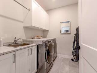 This laundry room features a convenient sink and ample counter space, perfect for folding clothes.