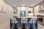 This modern kitchen boasts a sleek island with comfortable seating, perfect for casual dining or entertaining guests.