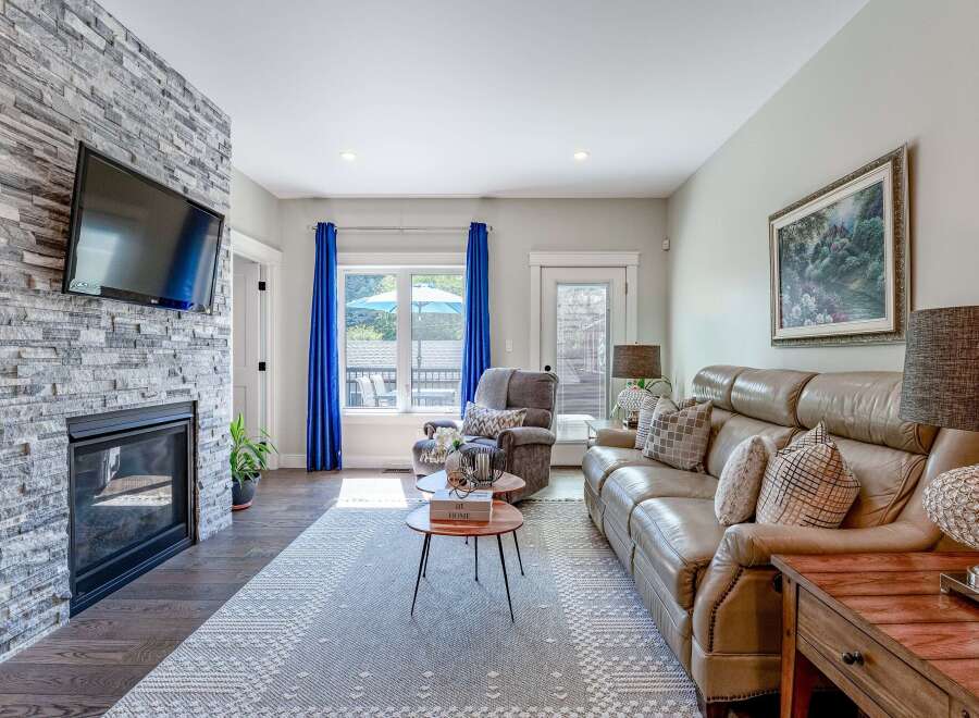 Experience modern living in this inviting living room, featuring a striking stone-clad fireplace with an integrated TV.