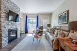 Experience modern living in this inviting living room, featuring a striking stone-clad fireplace with an integrated TV.