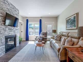 Experience modern living in this inviting living room, featuring a striking stone-clad fireplace with an integrated TV.
