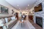 Experience modern living in this open-concept home featuring a spacious living area with a cozy fireplace and a large leather sofa.