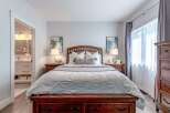 Experience ultimate comfort in this beautifully appointed bedroom, featuring a luxurious wooden bed frame and plush bedding.