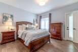 Experience comfort and style in this beautifully appointed bedroom, featuring a luxurious wooden bed frame with ample storage drawers.