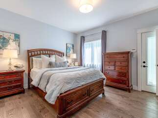 Experience comfort and style in this beautifully appointed bedroom, featuring a luxurious wooden bed frame with ample storage drawers.