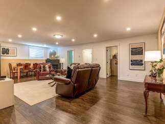 This spacious basement living area features a comfortable leather seating arrangement, perfect for relaxing or entertaining.