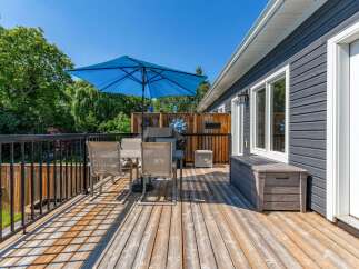 Enjoy outdoor living on this spacious wooden deck, perfect for entertaining guests or relaxing in the sun.