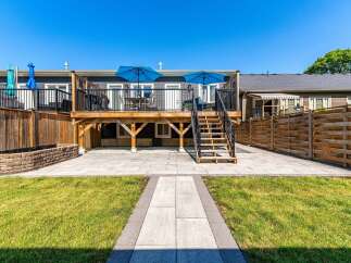 Enjoy outdoor living with this spacious backyard featuring a multi-level deck and a large stone patio, perfect for entertaining.