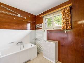 This bathroom features a classic bathtub with white tiled surround and a chrome faucet.