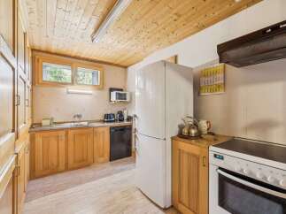This charming kitchen features warm wooden cabinetry and a coordinating wood-paneled ceiling, creating a cozy and inviting atmosphere.